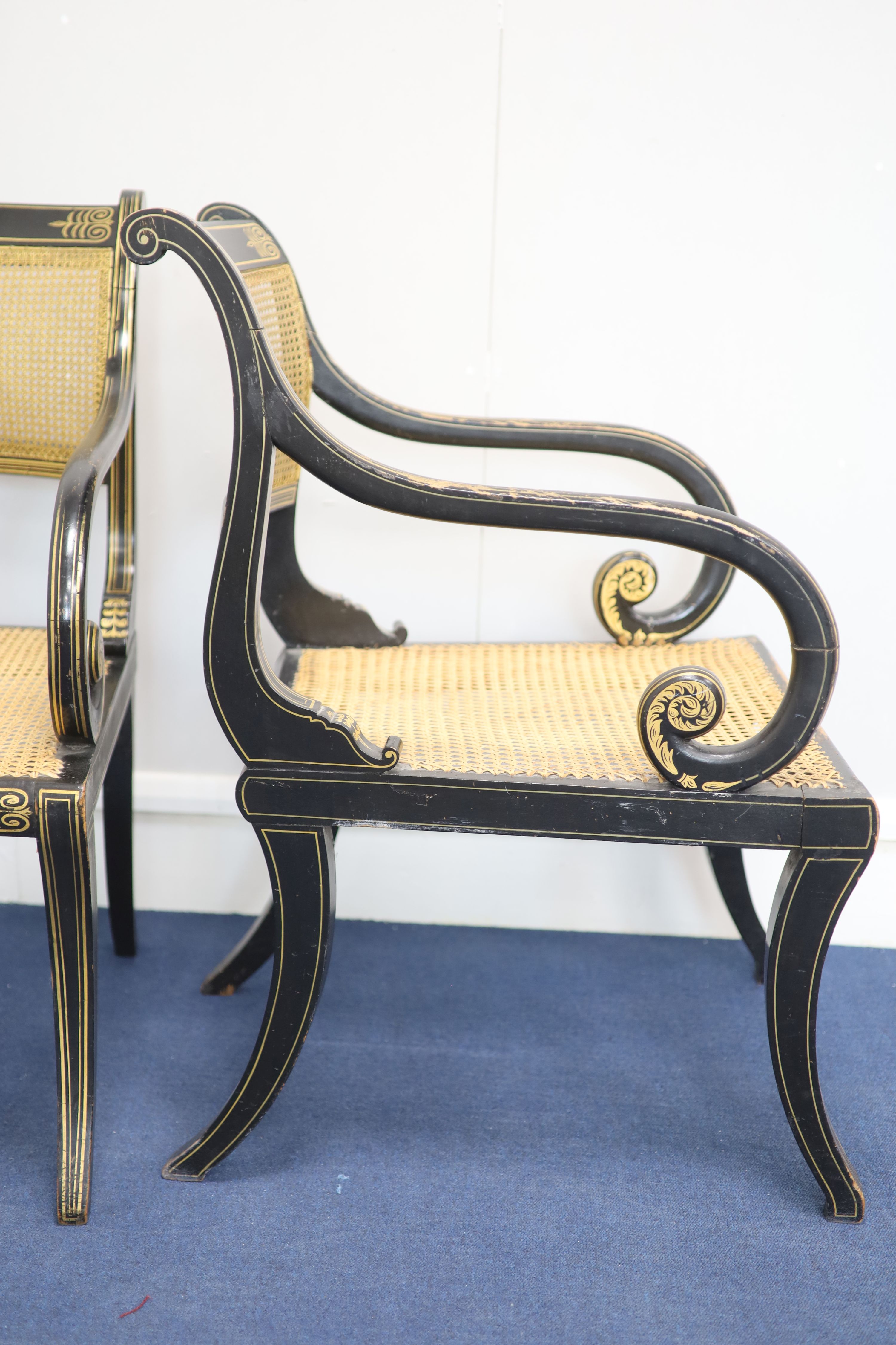 A set of seven Regency style parcel-gilt decorated ebonised armchairs, 19th century,